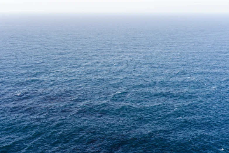 a lone boat floating in the middle of the ocean