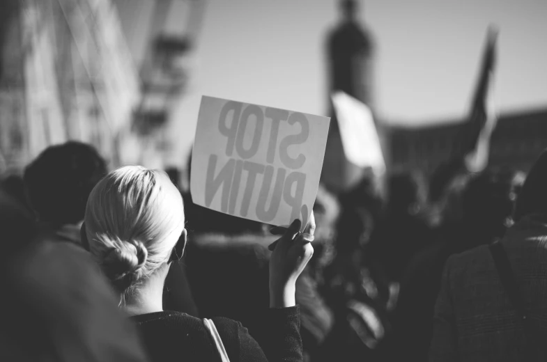 a person holding up a sign at a protest