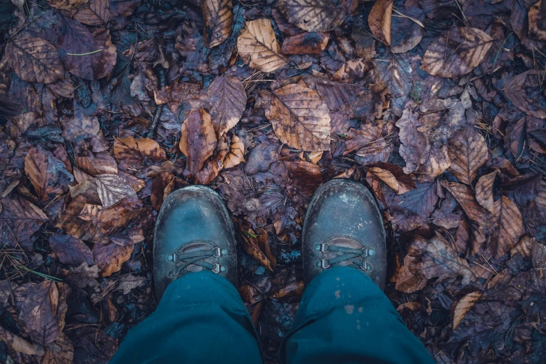 a man stands outside in leaves with shoes on