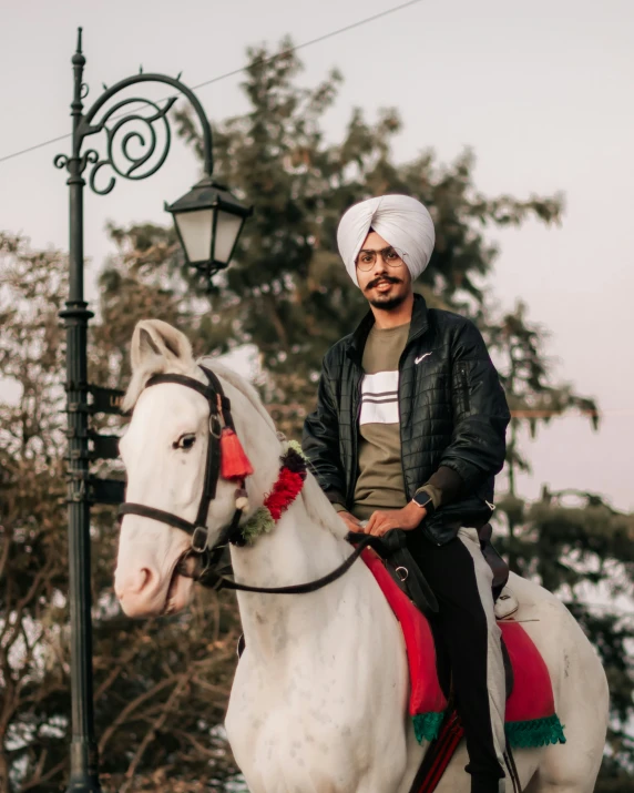 man sitting on top of a horse near a street light