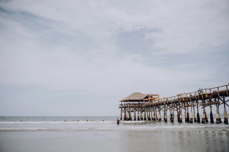 a tall pier sitting on the side of a beach