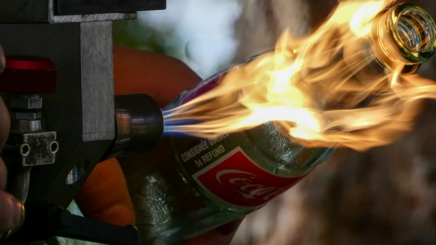 fire is lit as a person holds a can