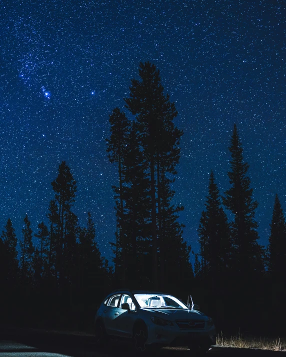 a car is shown in the foreground at night under stars
