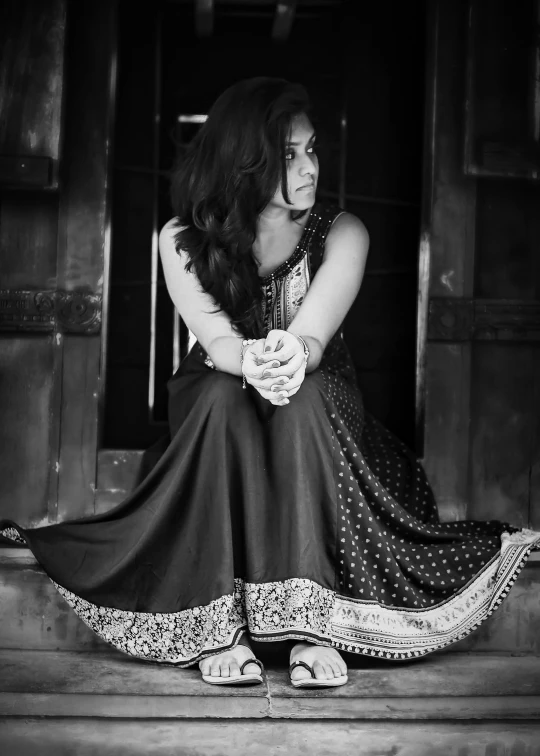 a woman sitting on a stair looking in a doorway