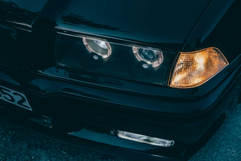 a close up po of the headlight and grille of a black sports car