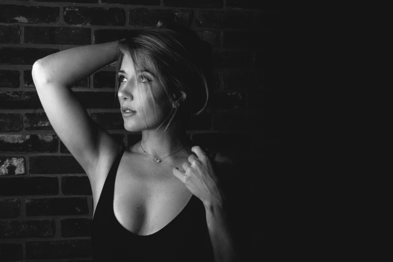 a black and white po of a woman posing with her hand on her head