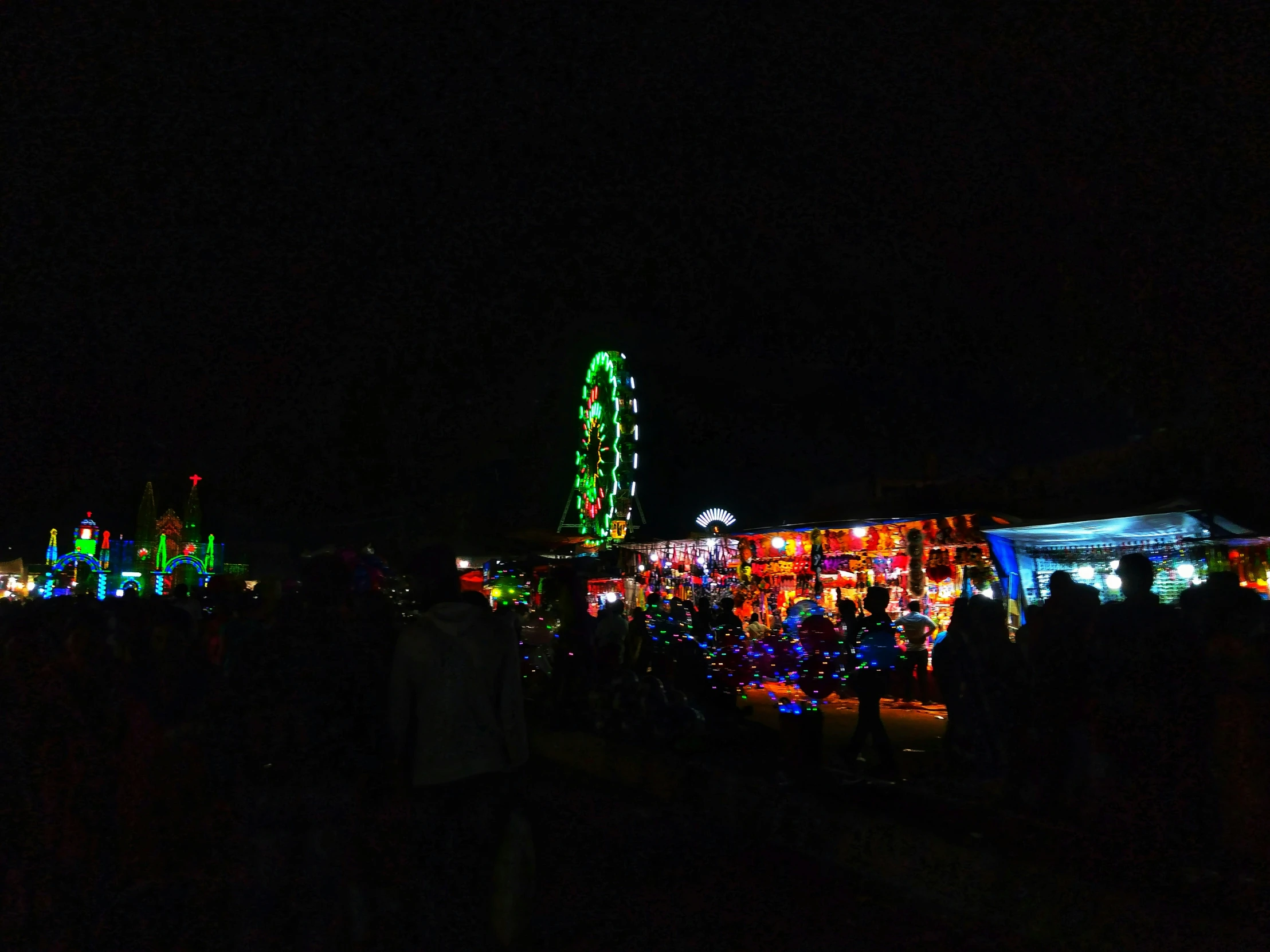 there are people at this holiday parade with a ferris wheel lit up