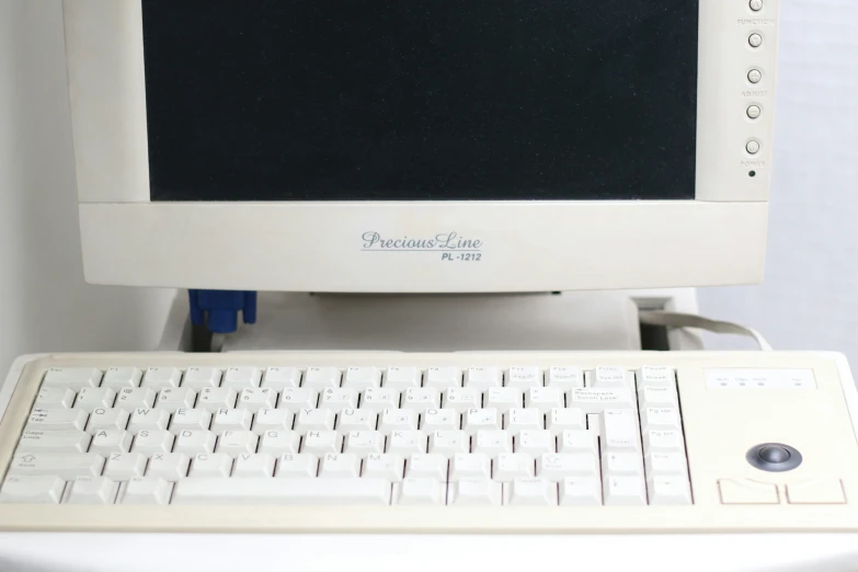 a computer with white keys is sitting on a desk