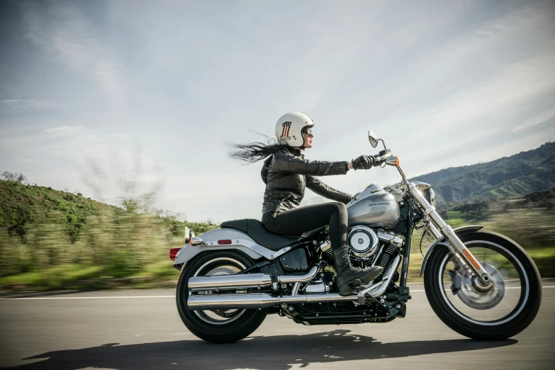 a woman rides a motorcycle on the road