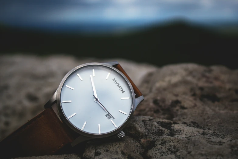 a watch is sitting on a large rock