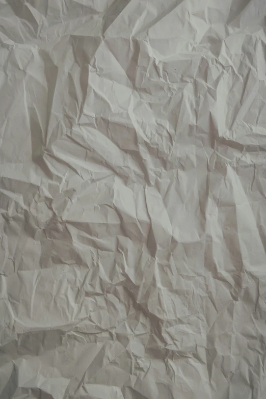 wrinkled paper on a surface with a black piece of wood