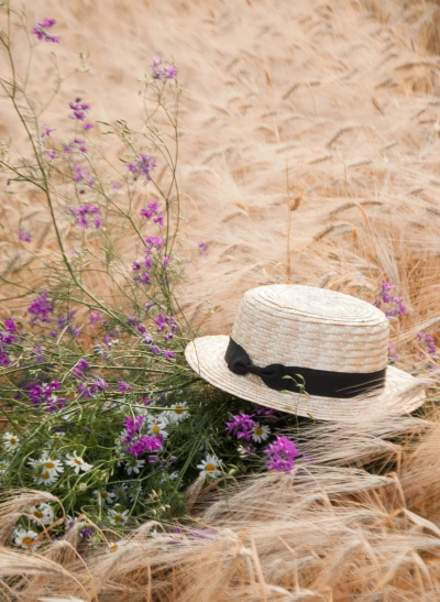 a hat sitting in the middle of a field full of wildflowers