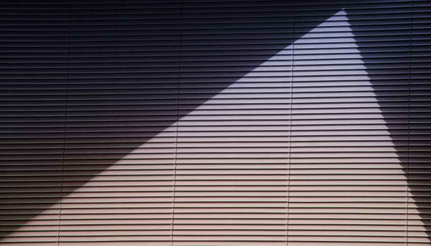 an angled view of blinds with the light coming from them