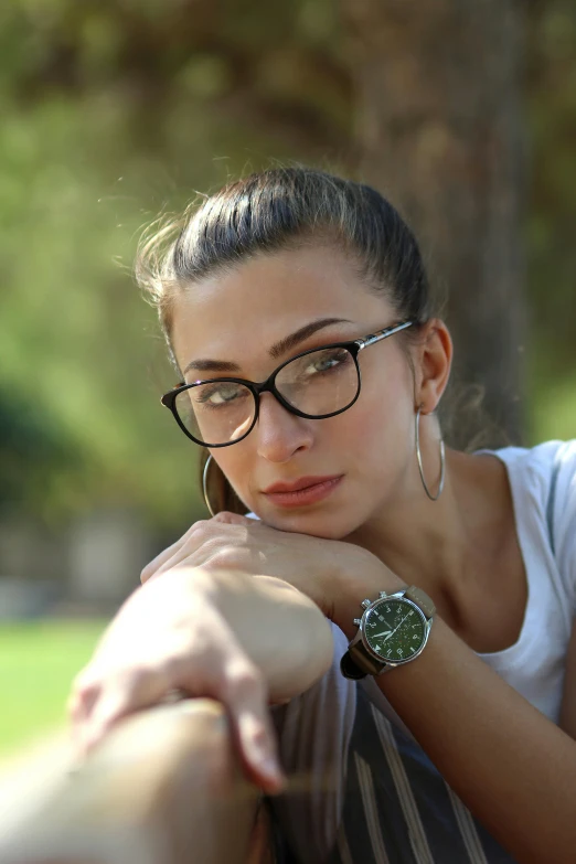 woman wearing glasses and a  shirt looks into the distance