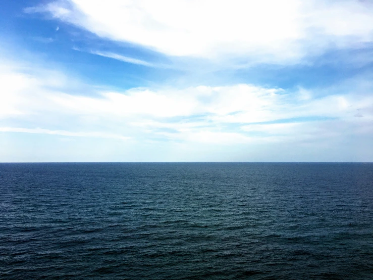 large open body of water under a cloudy blue sky