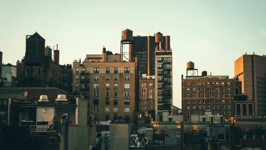 a city skyline with large buildings and buildings lit up at dusk