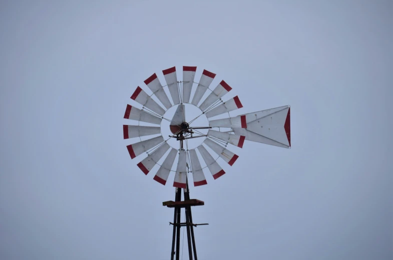 a wind turbine on top of a windmill with red and white tops