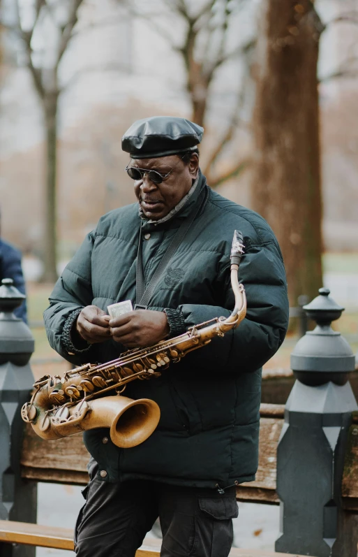 man with saxophone in the rain in city