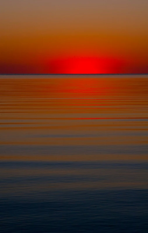 red and yellow sunset over calm waters at beach