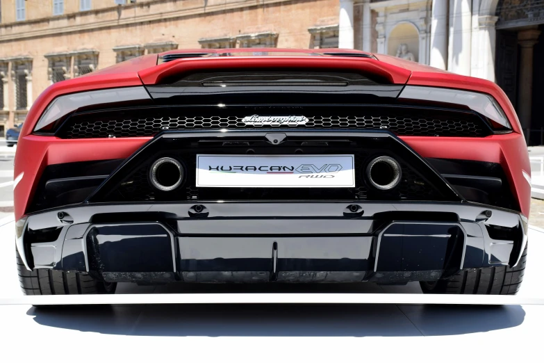 a black, red and silver sports car is parked in front of an old building