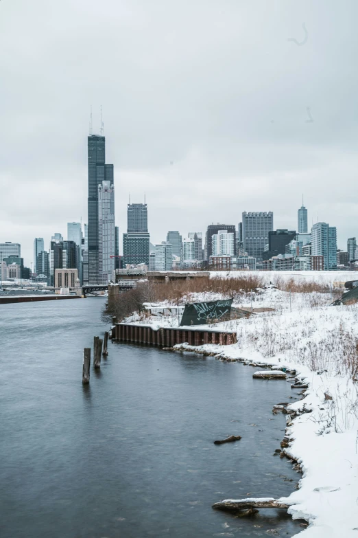 snow on the ground and water in front of a city