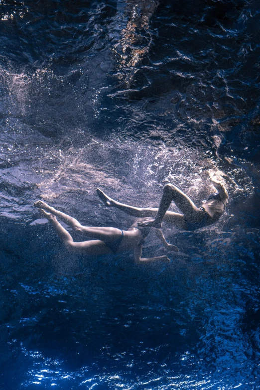 a woman is seen floating on water under a wave