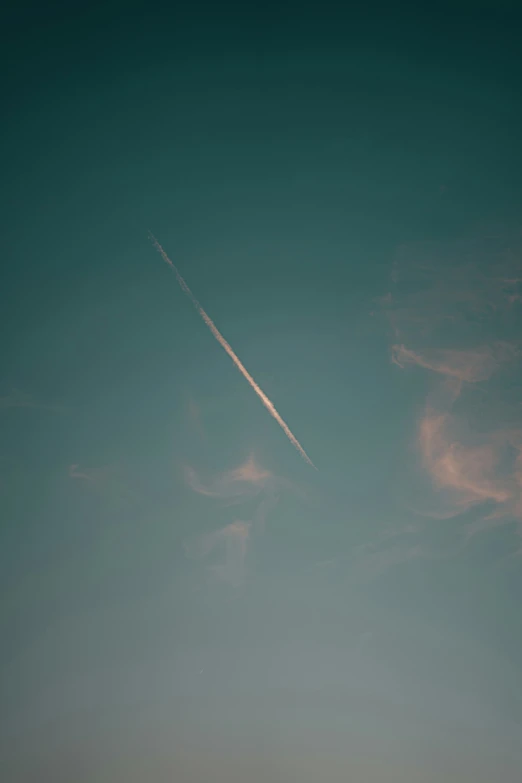 a contrail is flying high in the sky