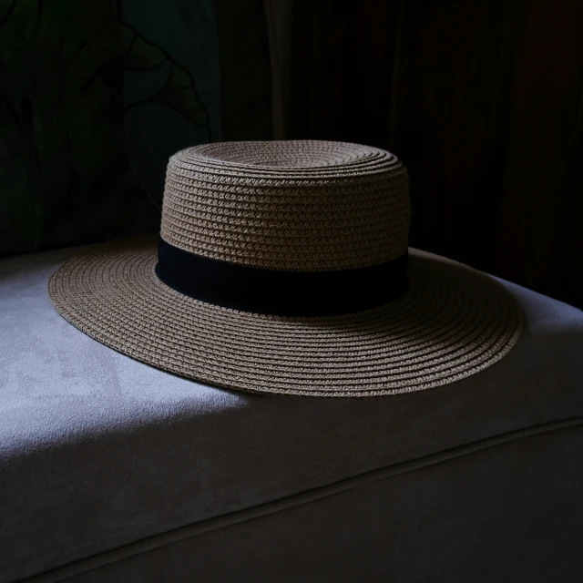a hat on the back of a couch with an object in the corner