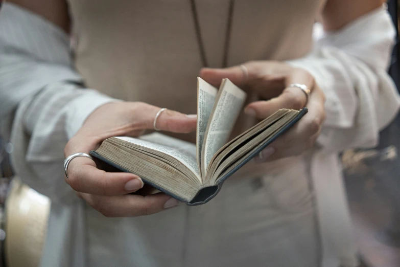 the hands of a person holding a book