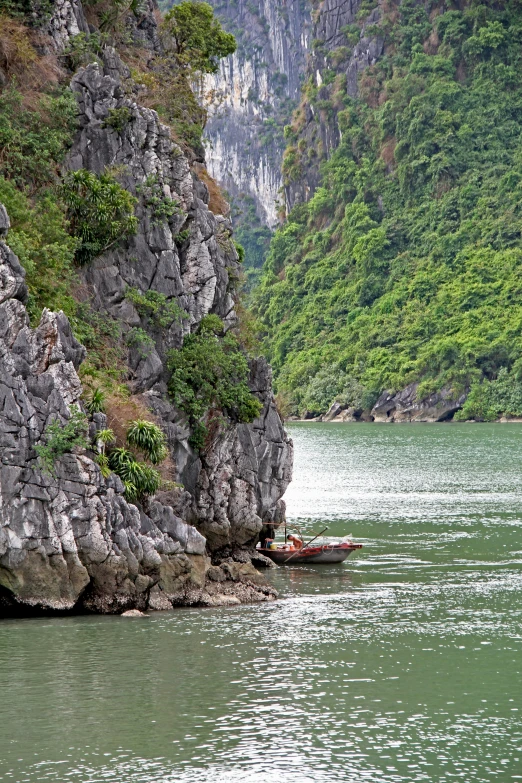 there is an empty boat on the water by the rocks