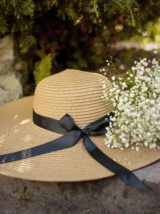 a straw hat with a ribbon and a flower