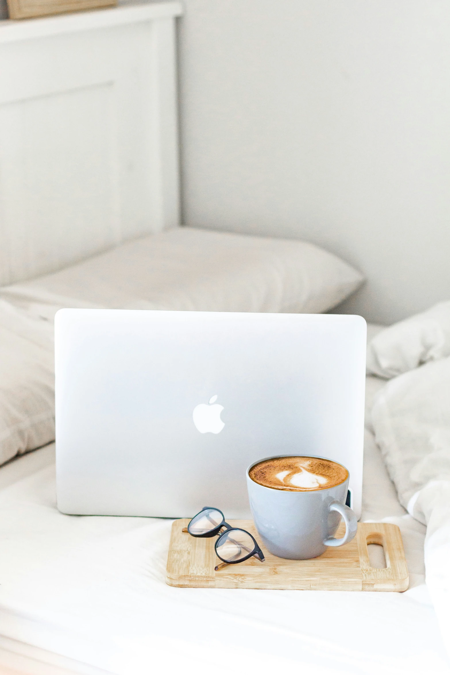 a cup of coffee sitting next to an apple laptop