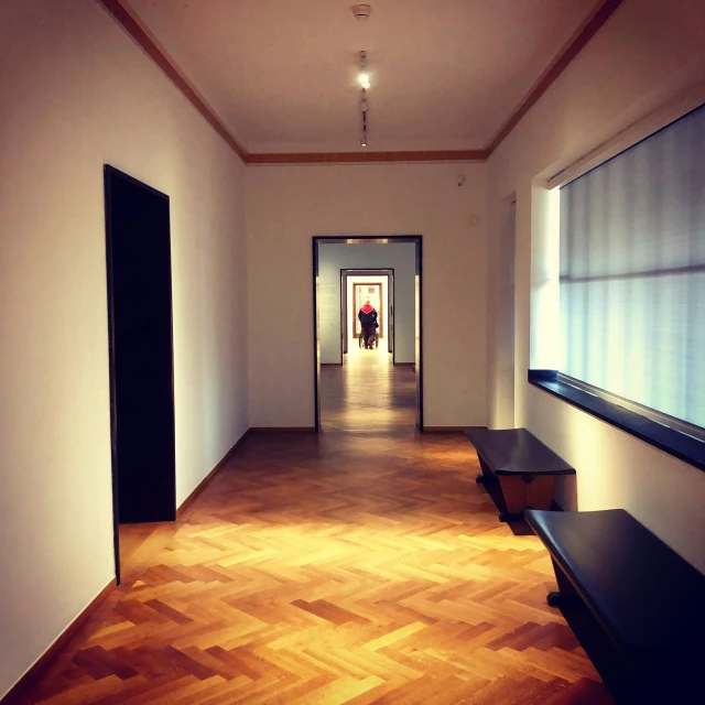 an empty hallway with two benches on both sides