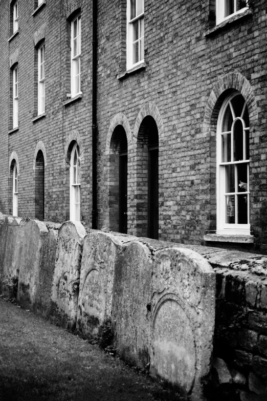 a black and white pograph of some windows in the wall