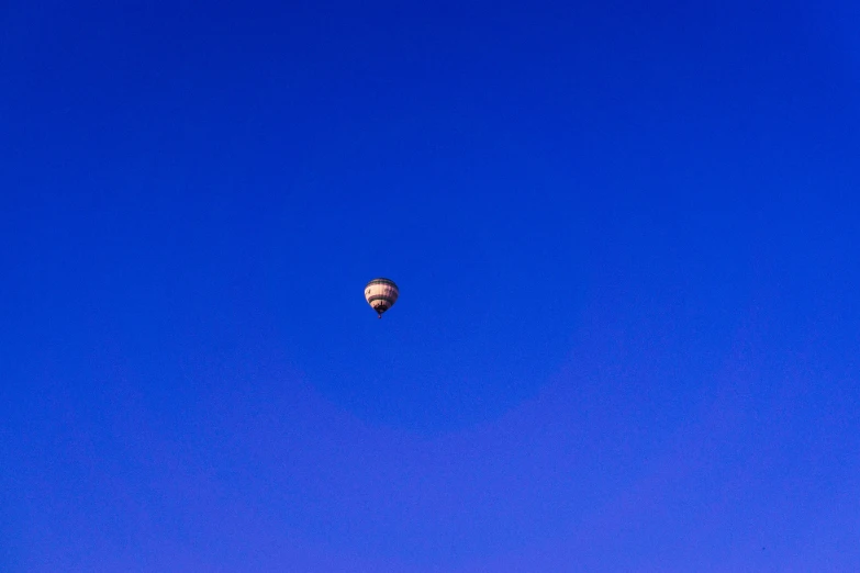 a  air balloon is floating high in the sky