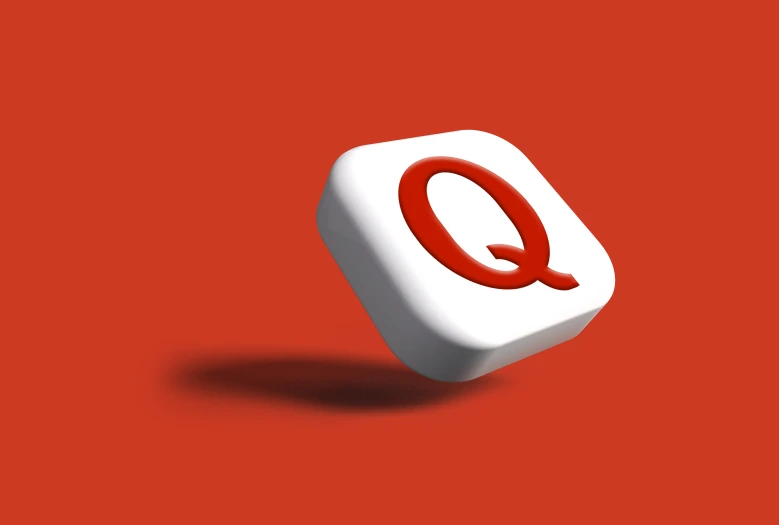 a dice with a q on top on red background