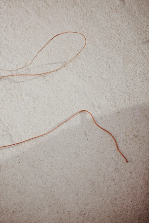 an orange string of some sort on sand