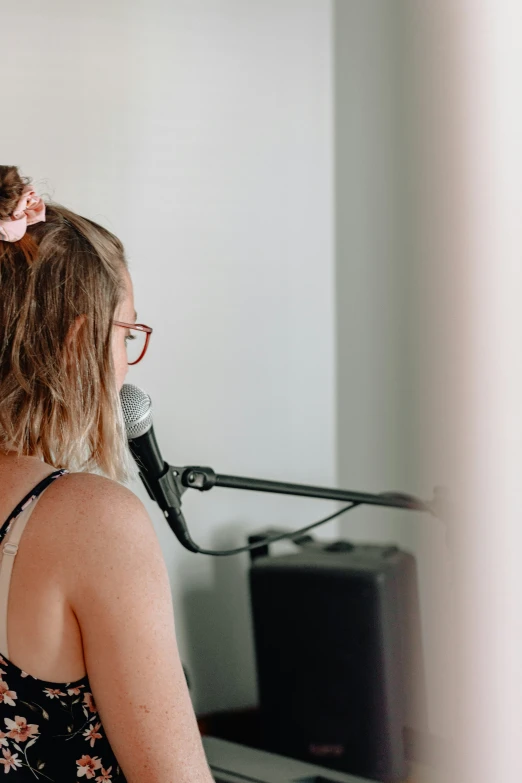 the girl stands before of an up - close microphone in front of her