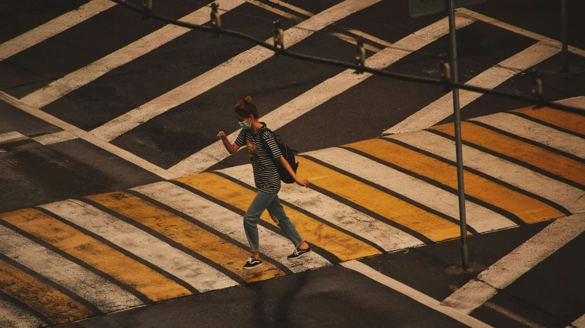 an aerial po of a cross walk, with pedestrian and traffic