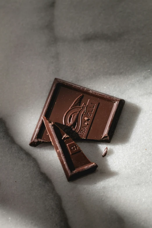 a piece of chocolate next to another on white surface