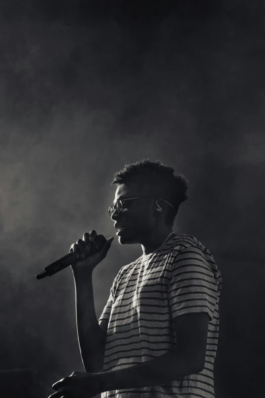 a woman holding a microphone up in front of a stage