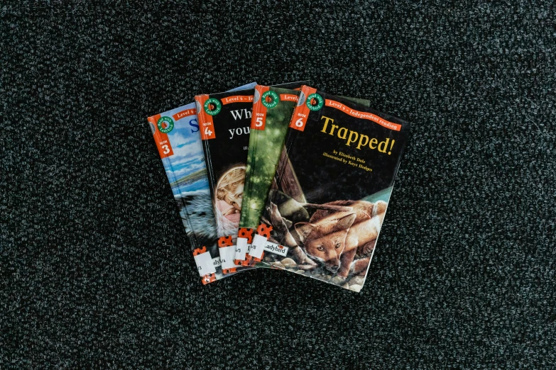 three magazines on a black surface are shown
