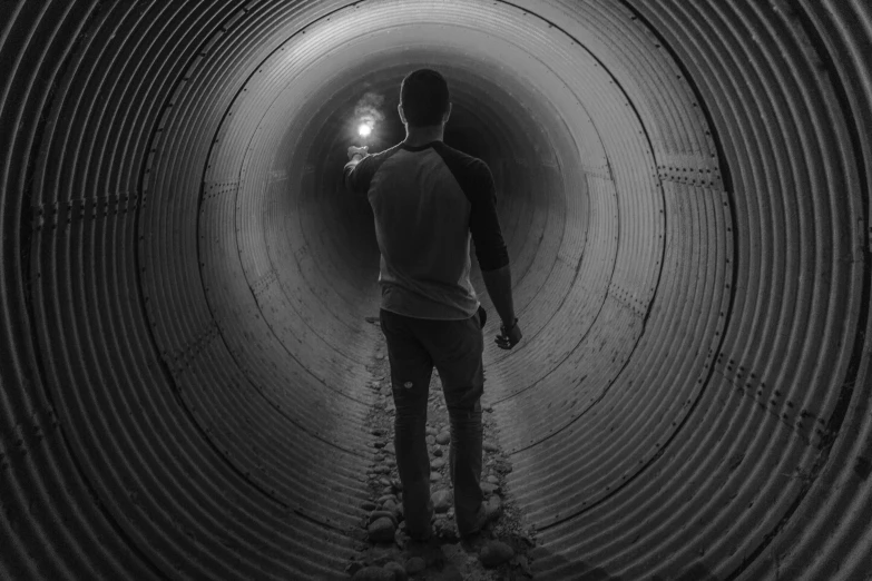 a man standing in the middle of a long tube