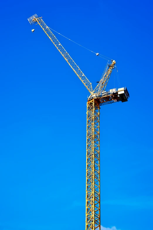 a crane sits atop a construction site under a clear blue sky