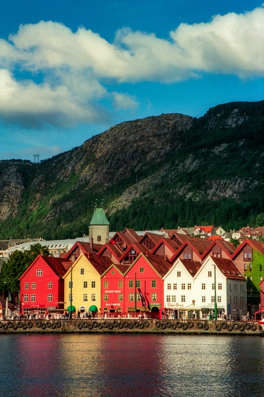 a row of red and yellow buildings line the side of a lake