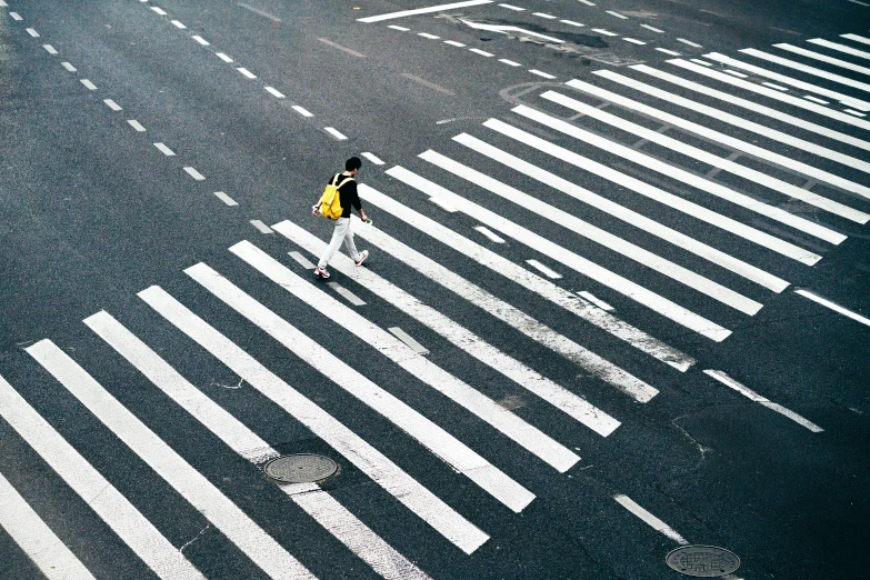 an overhead view of a person walking across a crosswalk