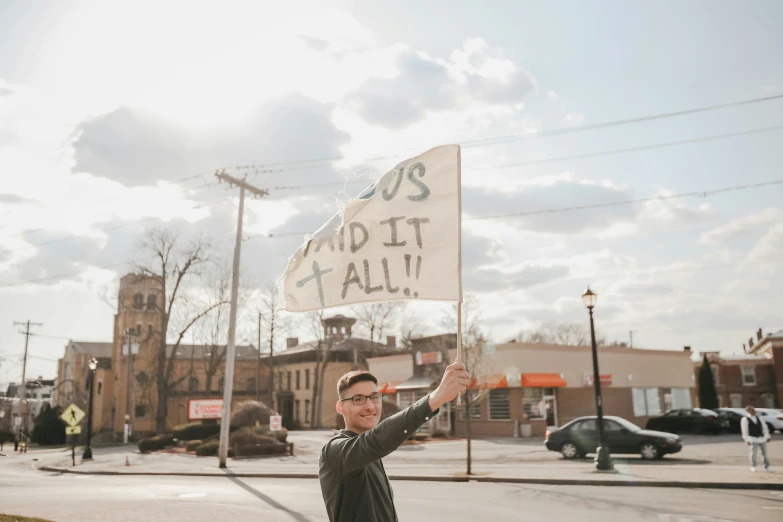 a man holding up a sign with words written on it