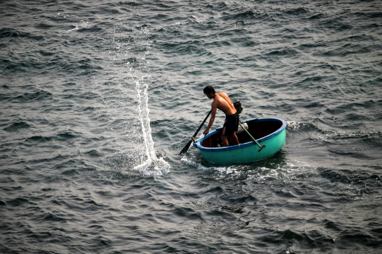 man rowing his boat in the open water