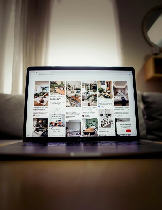 a laptop computer sitting on a table with pictures on it