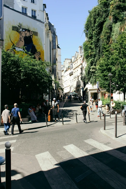 people walking down a city street next to tall buildings